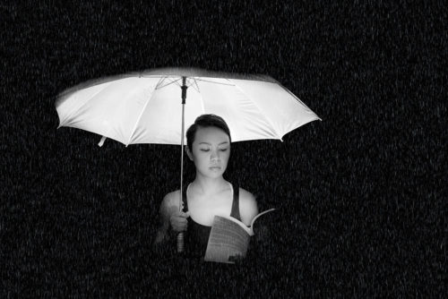 Photo of a woman with a book and umbrella